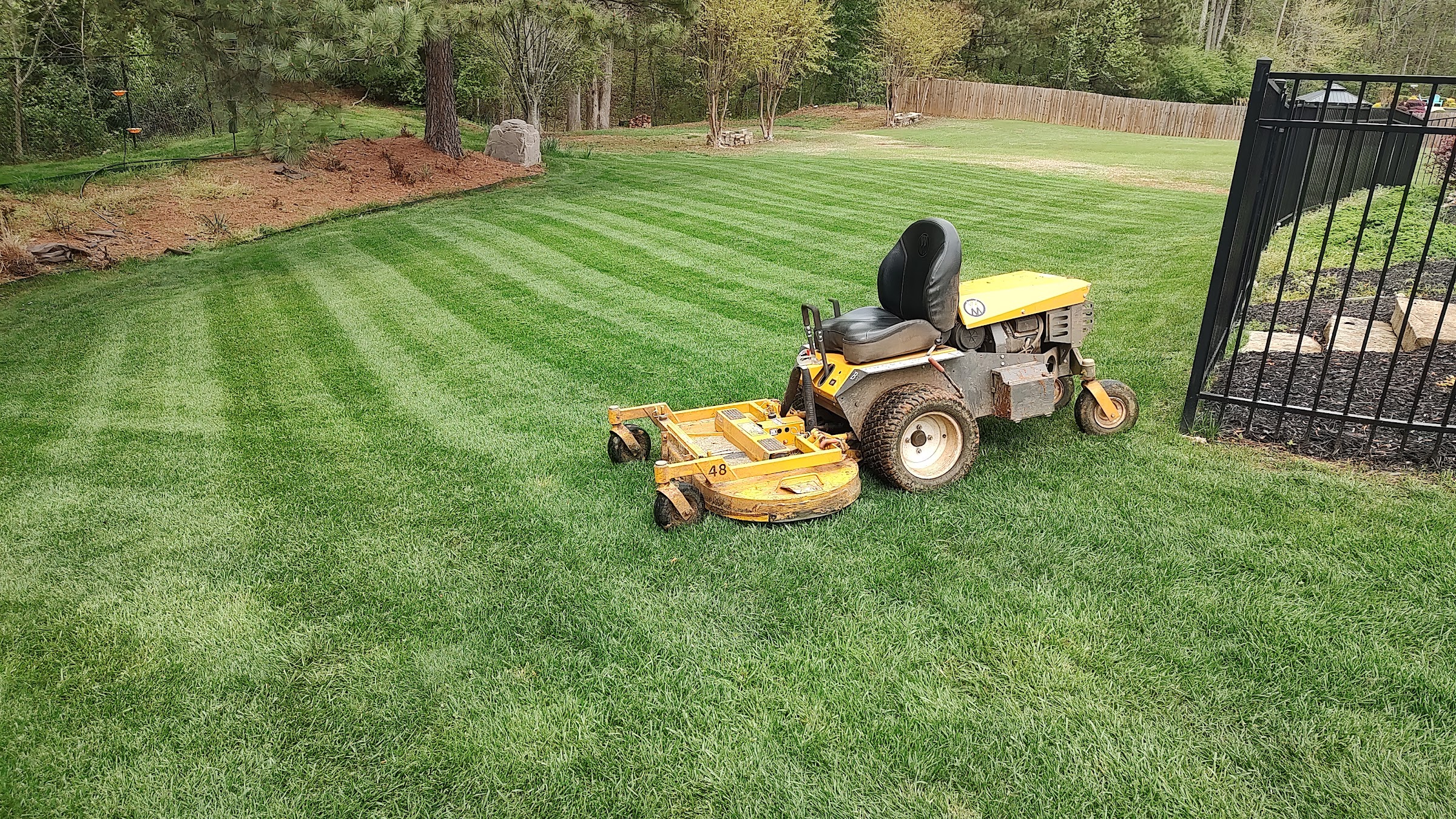 A zero-turn mower on a freshly striped green lawn by Lawn N Order of GA