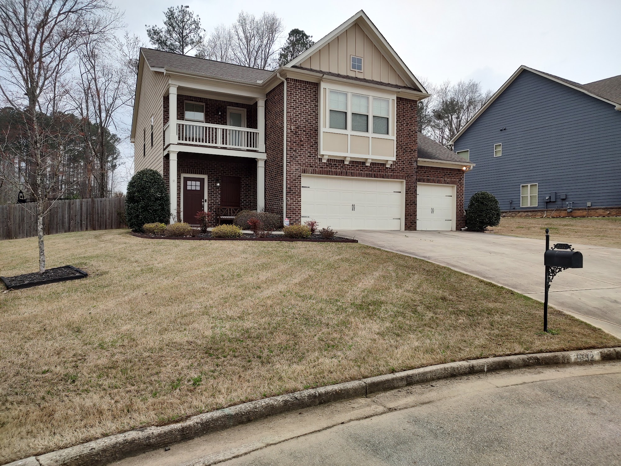 A two-story brick home with a tidy front lawn in metro Atlanta